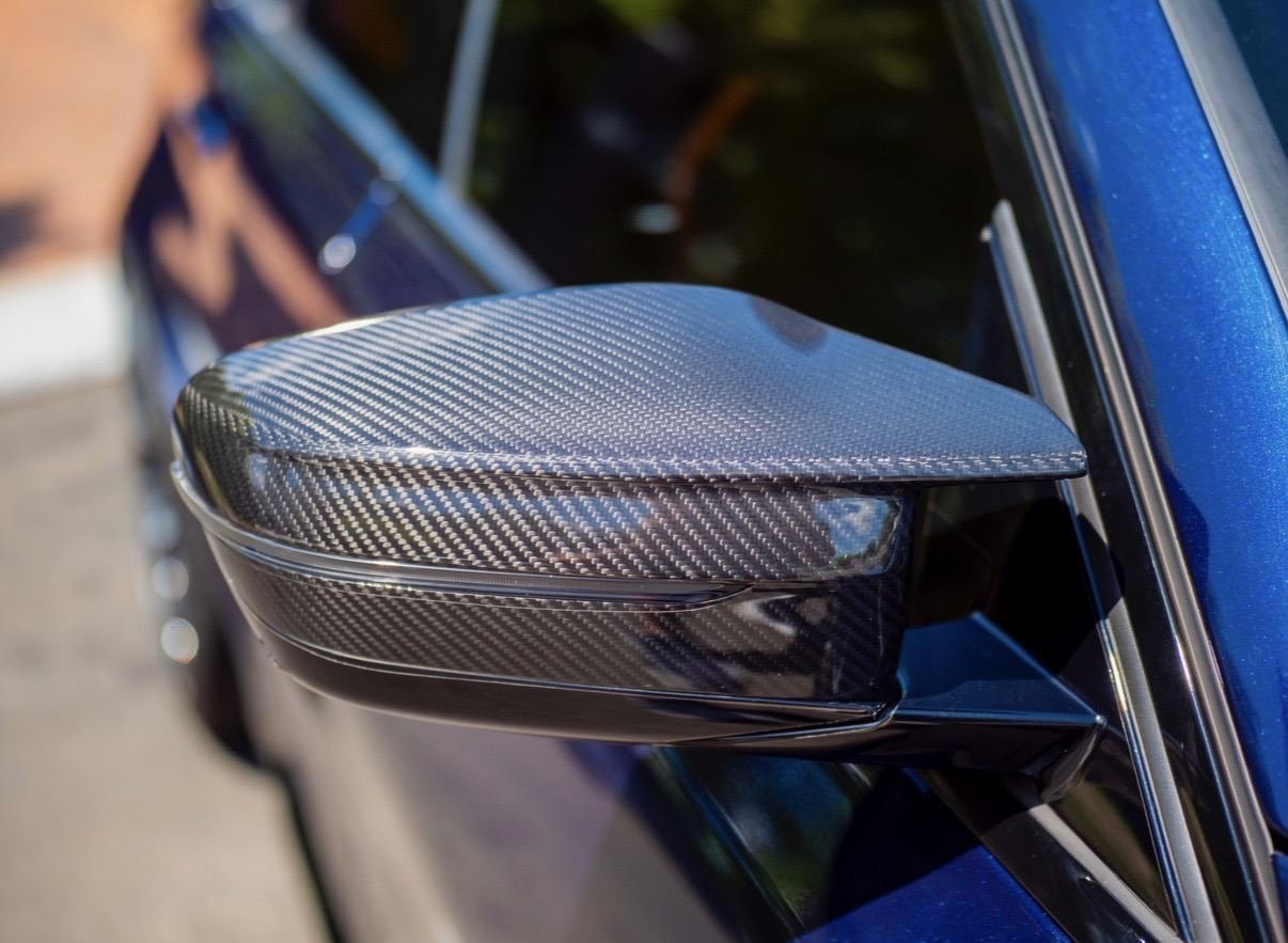 Carbon fibre mirror cap on a blue BMW, freshly detailed